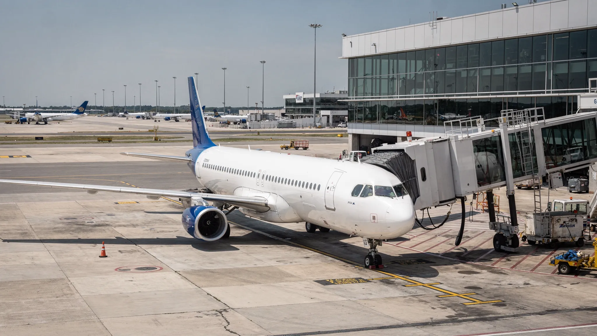 Commercial passenger jet taxiing at an airport gate with boarding bridge, representing the air transportation excise tax on tickets and segments.